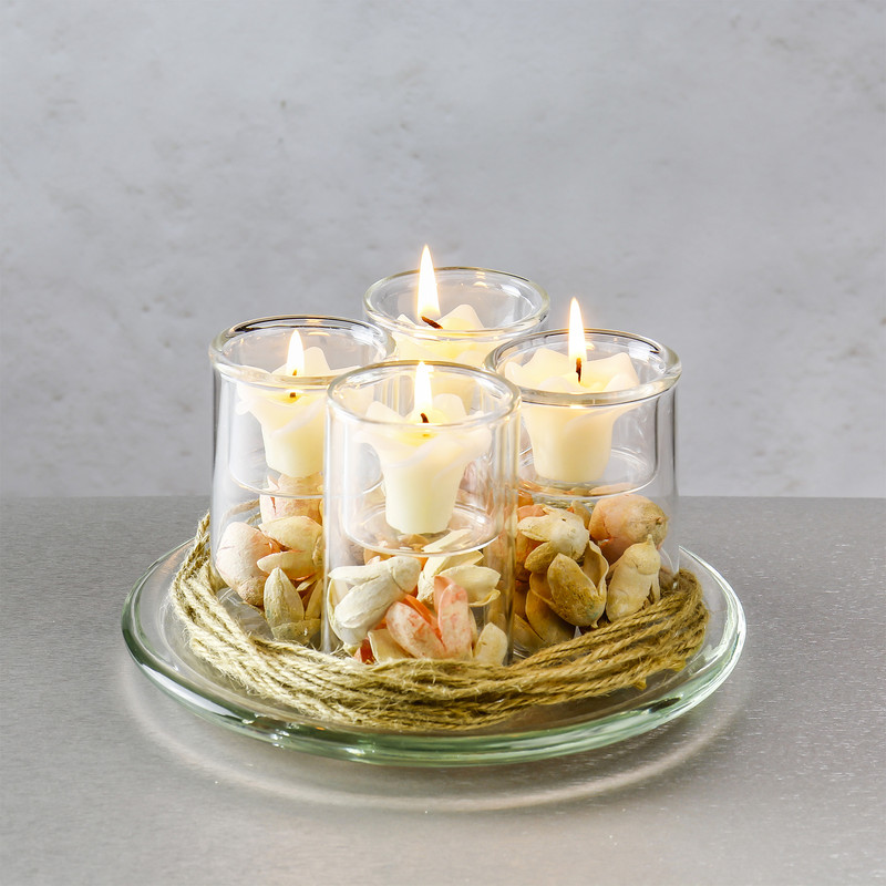 A set of four 3.75 inch tealight votive candleholders on a glass candle plate